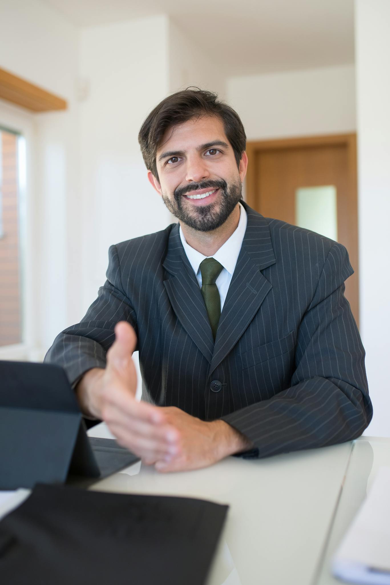 Real estate agent smiling in a modern office environment, ready for business transactions.